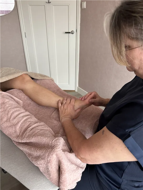 Anja behandelt de voet van een cliënt tijdens een voetreflexbehandeling